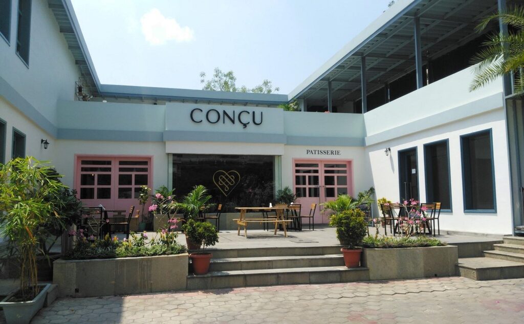Front view of Conçu Café, one of the Top 5 Budget-Friendly Cafes in Hyderabad, with elegant outdoor seating and modern architecture.